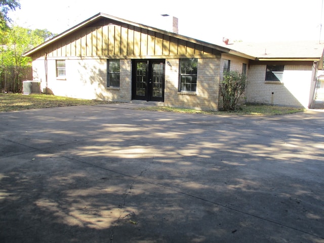 ranch-style house featuring french doors and central AC unit