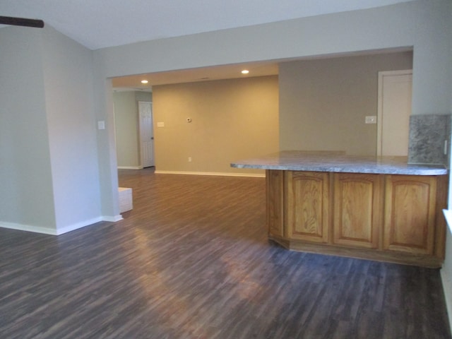 interior space with kitchen peninsula and dark wood-type flooring