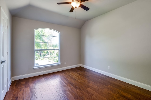 empty room featuring dark wood-style floors, lofted ceiling, baseboards, and a ceiling fan