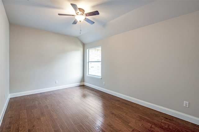 empty room featuring dark hardwood / wood-style flooring, vaulted ceiling, and ceiling fan