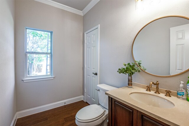 bathroom with toilet, hardwood / wood-style floors, vanity, and ornamental molding