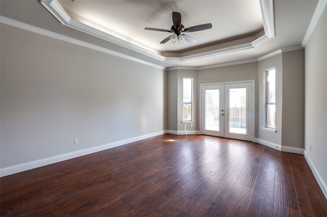 unfurnished room with dark wood-type flooring, french doors, ceiling fan, ornamental molding, and a tray ceiling