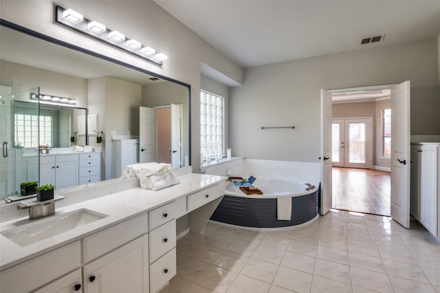 bathroom featuring tile patterned flooring, vanity, a wealth of natural light, and french doors