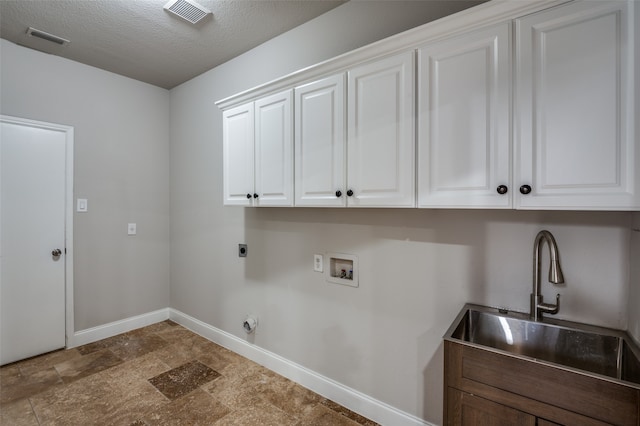 clothes washing area featuring cabinets, sink, washer hookup, a textured ceiling, and hookup for an electric dryer