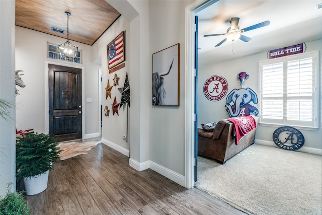 entrance foyer with ceiling fan with notable chandelier, wood-type flooring, and wooden ceiling