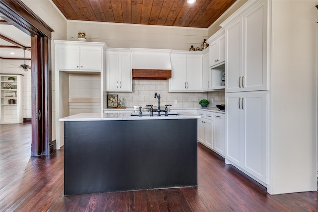 kitchen featuring white cabinets, a kitchen island with sink, dark wood-type flooring, and wood ceiling