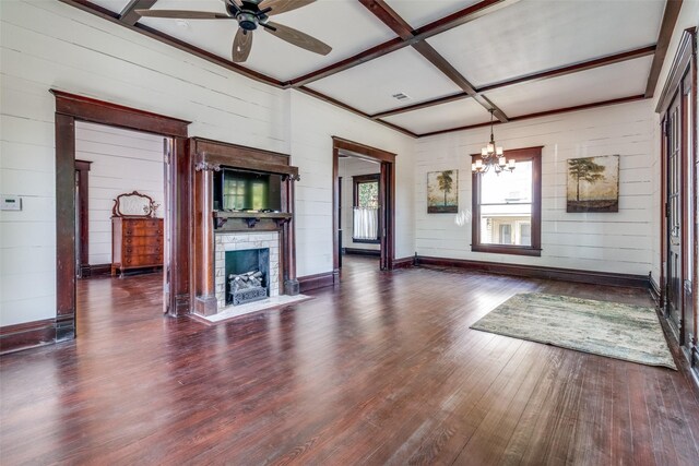 unfurnished living room with dark hardwood / wood-style flooring, coffered ceiling, ceiling fan with notable chandelier, a fireplace, and wood walls