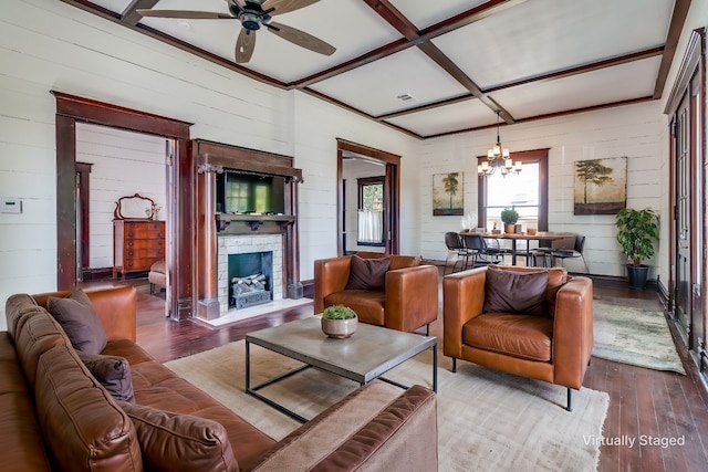 living room featuring ceiling fan with notable chandelier, wood-type flooring, wooden walls, and coffered ceiling