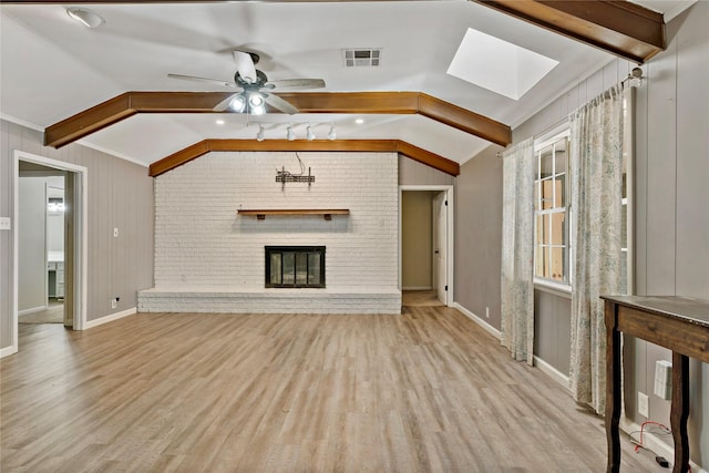 2680 Hubbard St, Paris, TX 75460 - unfurnished living room with wood finished floors, a skylight, a brick fireplace, ceiling fan, and baseboards
