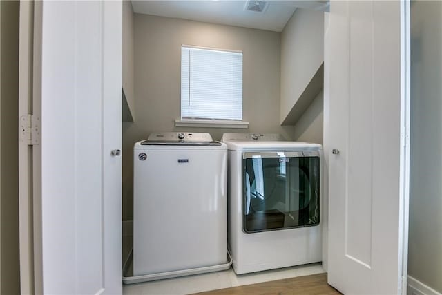 washroom with light wood-type flooring and separate washer and dryer