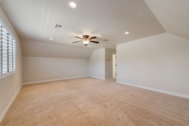 additional living space with ceiling fan, light colored carpet, and lofted ceiling