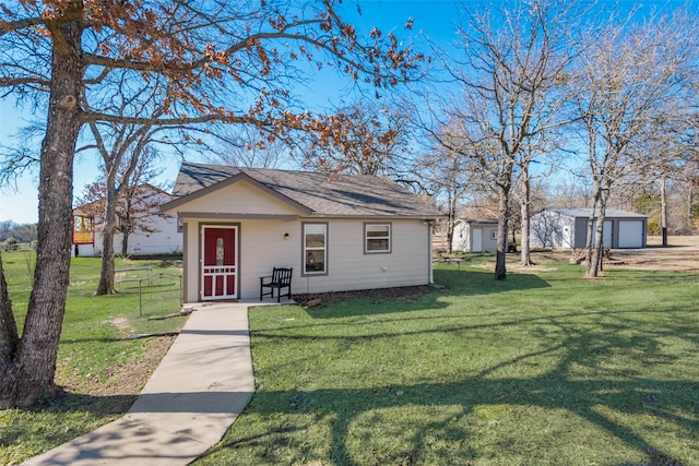 view of front of house featuring an outbuilding and a front lawn