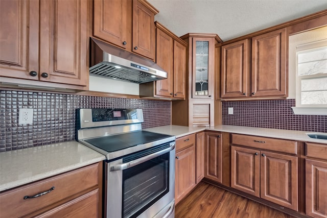 kitchen with decorative backsplash, a textured ceiling, dark hardwood / wood-style floors, and stainless steel range with electric stovetop