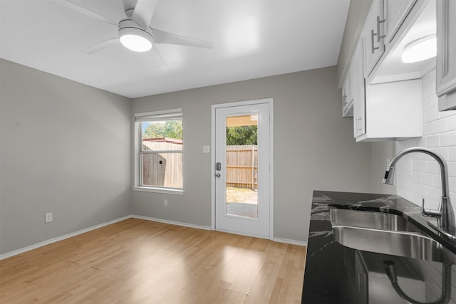 kitchen with sink, ceiling fan, tasteful backsplash, light hardwood / wood-style floors, and white cabinetry