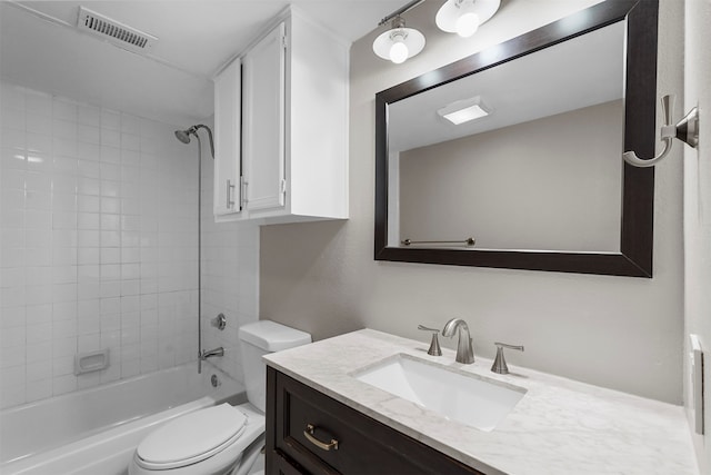 full bathroom featuring tiled shower / bath combo, toilet, and vanity