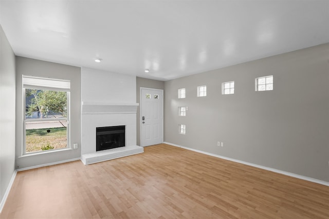 unfurnished living room featuring a fireplace and light hardwood / wood-style flooring