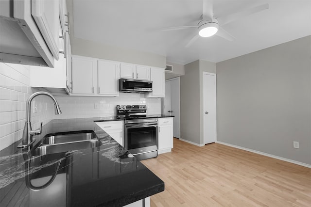 kitchen with backsplash, white cabinets, sink, light hardwood / wood-style floors, and stainless steel appliances