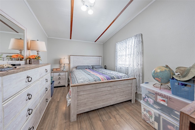 bedroom with light hardwood / wood-style flooring, vaulted ceiling, and ornamental molding