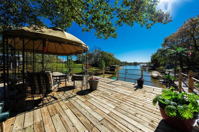 deck with a gazebo and a water view