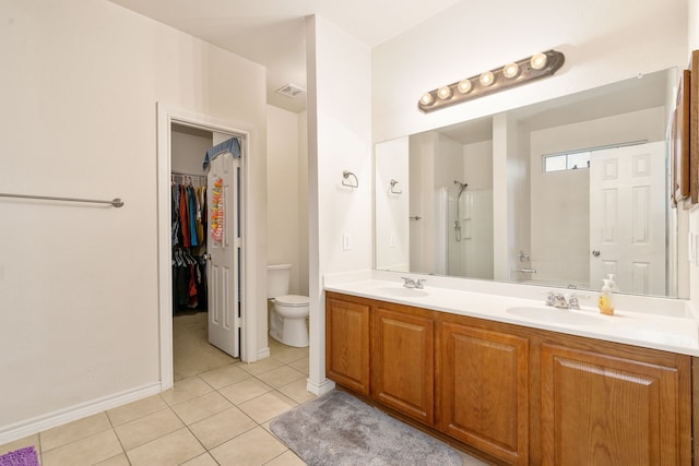 bathroom with tile patterned floors, vanity, toilet, and a shower