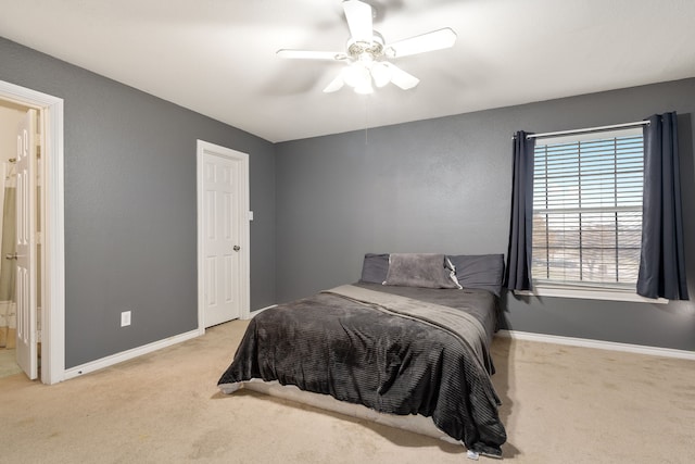 bedroom with ceiling fan, ensuite bathroom, and light colored carpet