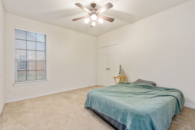 bedroom featuring ceiling fan, a closet, and light carpet