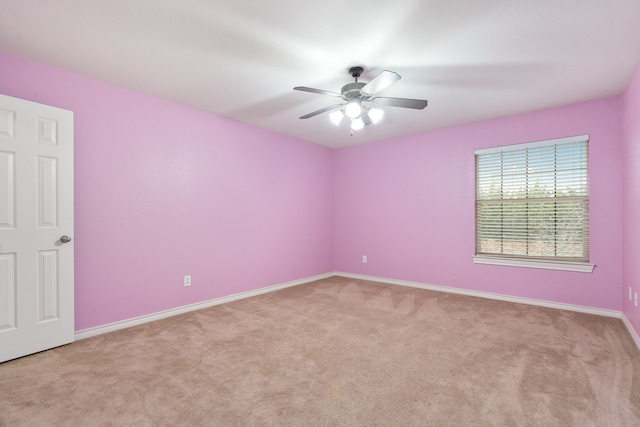 spare room with ceiling fan and light colored carpet