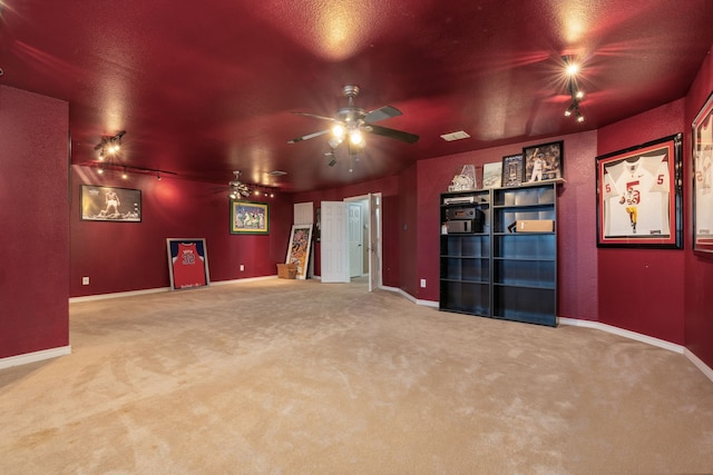 carpeted cinema room with ceiling fan