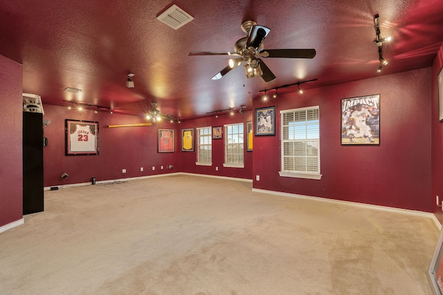 carpeted home theater featuring ceiling fan, a textured ceiling, and track lighting