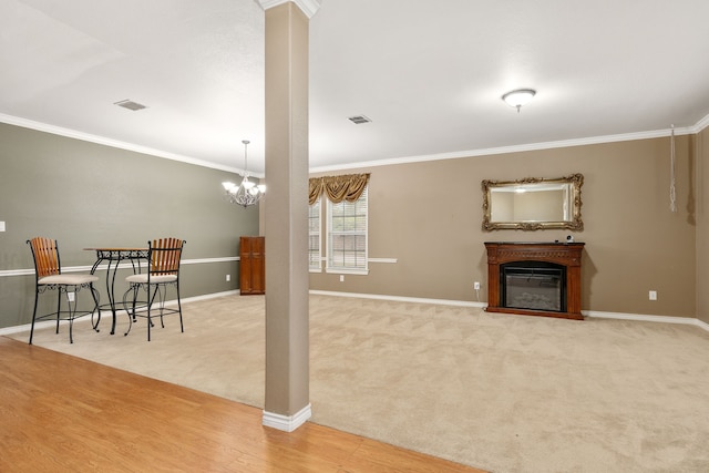 living room with light colored carpet, ornamental molding, and a notable chandelier