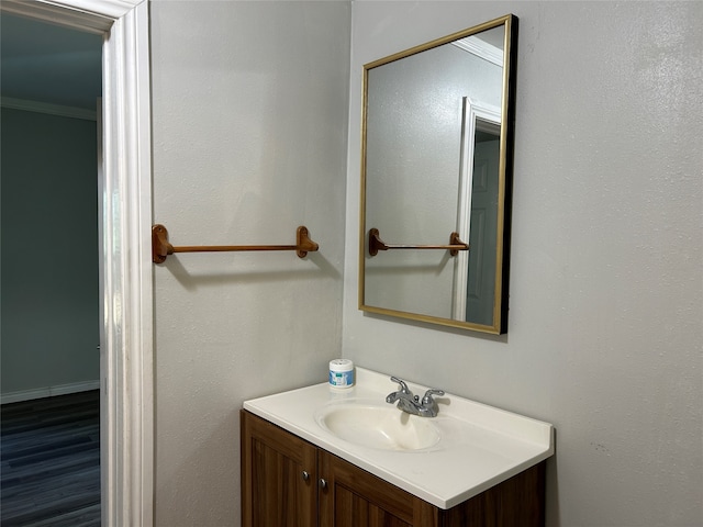 bathroom with wood-type flooring, vanity, and crown molding