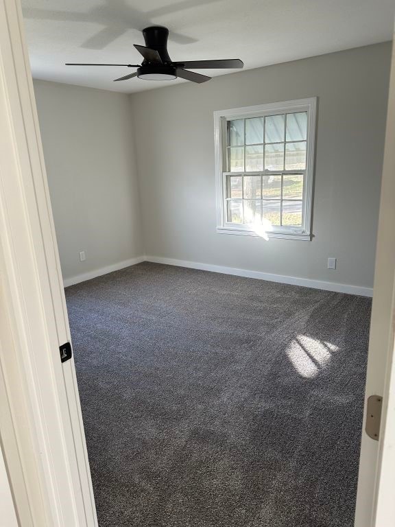 carpeted empty room featuring ceiling fan