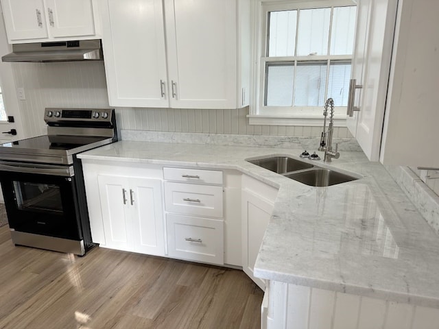 kitchen with light stone countertops, ventilation hood, sink, electric stove, and white cabinetry