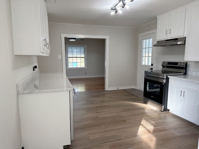 kitchen with white cabinets, hardwood / wood-style floors, electric range, and light stone counters