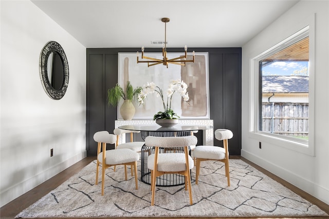 dining area featuring hardwood / wood-style floors, an inviting chandelier, and a healthy amount of sunlight