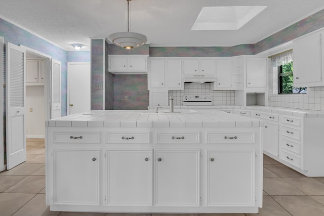 kitchen with a skylight, white cabinetry, a center island with sink, and electric stove