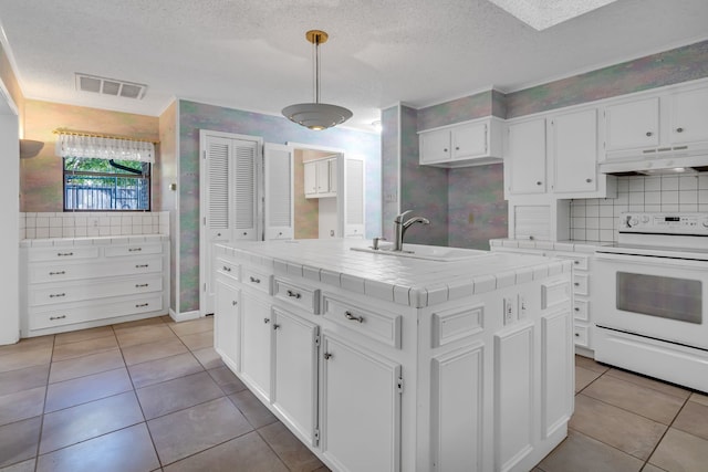 kitchen with premium range hood, sink, tile countertops, decorative light fixtures, and white electric range