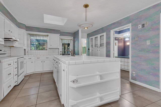 kitchen with sink, tile countertops, decorative light fixtures, white cabinets, and white range with electric cooktop