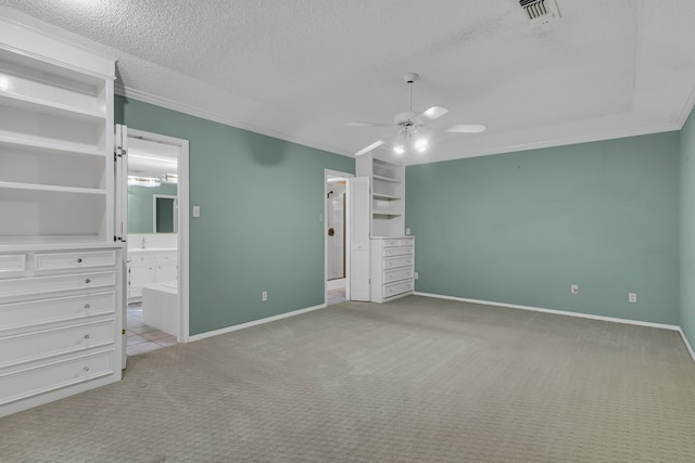 unfurnished bedroom with ensuite bath, ceiling fan, crown molding, light colored carpet, and a textured ceiling