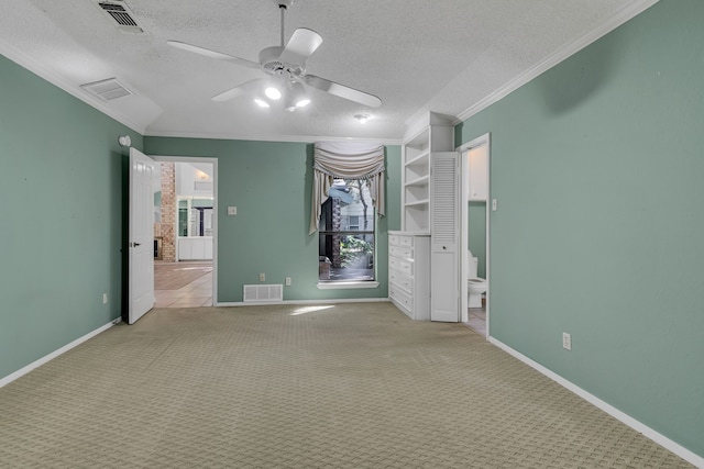 unfurnished bedroom featuring ceiling fan, ornamental molding, a textured ceiling, and light carpet