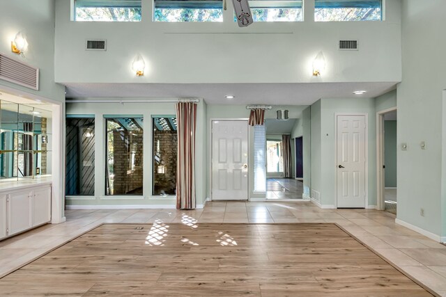 tiled entrance foyer featuring a towering ceiling and a wealth of natural light