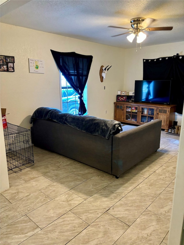 living room with a textured ceiling and ceiling fan