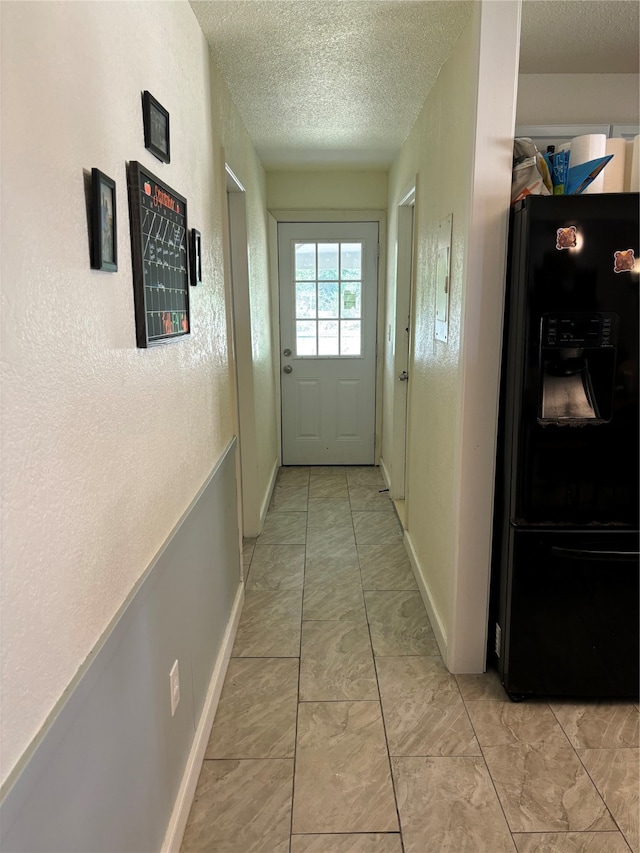 doorway to outside with a textured ceiling