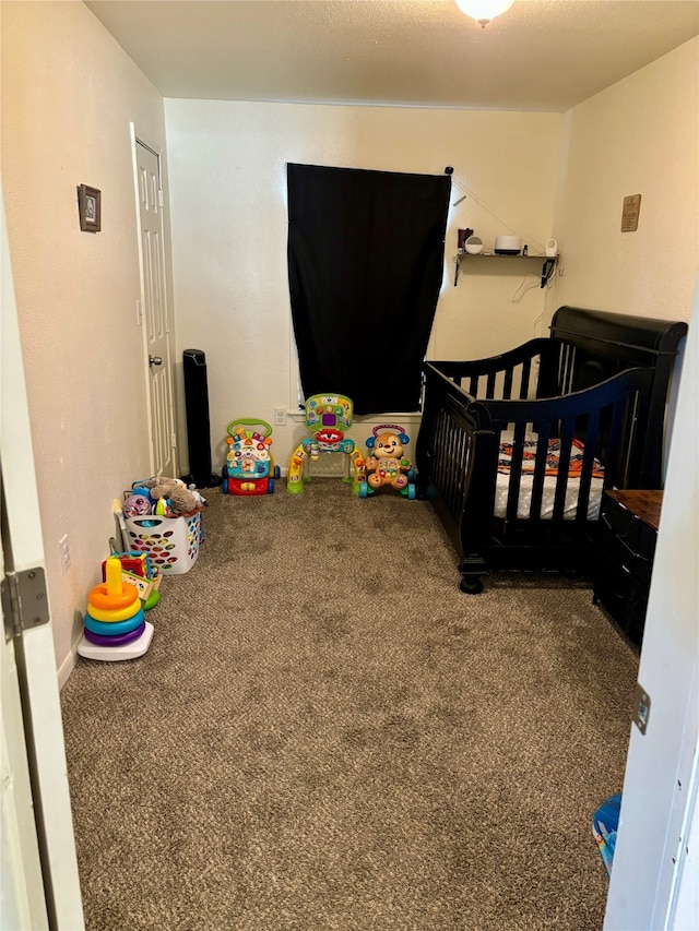 carpeted bedroom featuring a nursery area