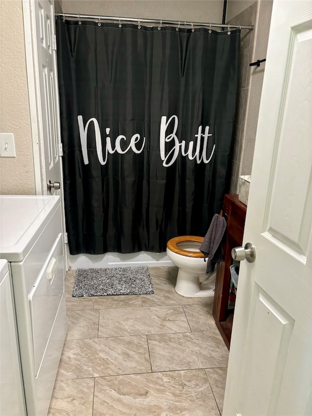 bathroom with toilet, independent washer and dryer, and walk in shower