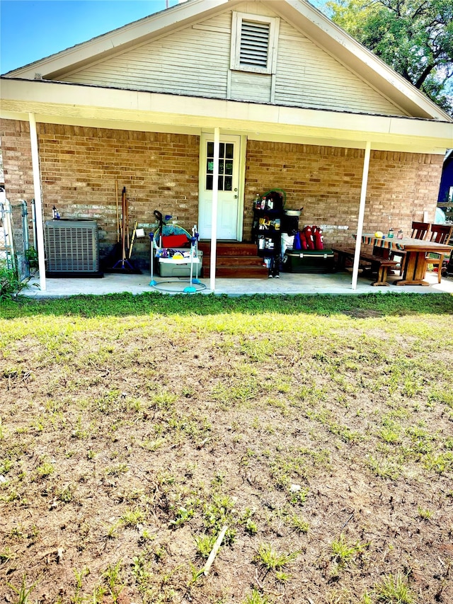 rear view of house featuring a yard, cooling unit, and a patio area