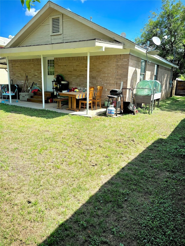 rear view of house featuring a patio and a lawn