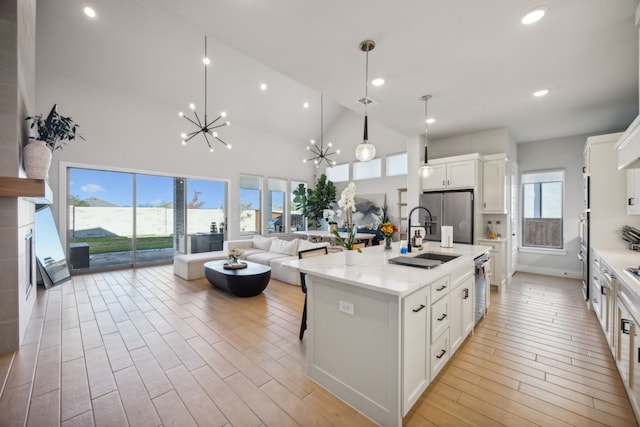 kitchen with white cabinetry, sink, a large island, hanging light fixtures, and stainless steel appliances