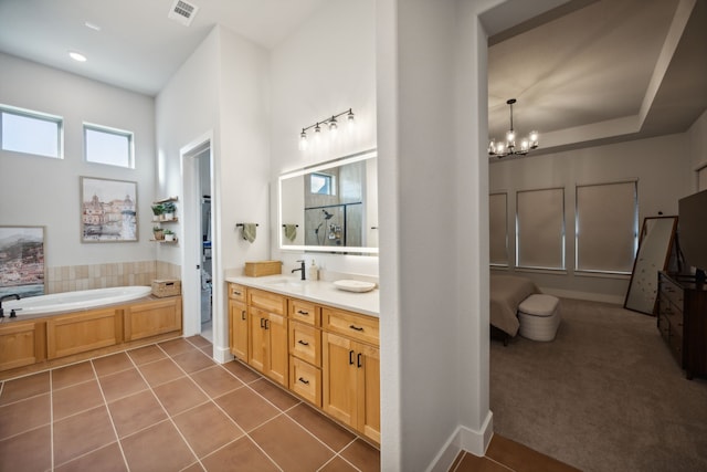 bathroom with tile patterned floors, a notable chandelier, a bath, and vanity