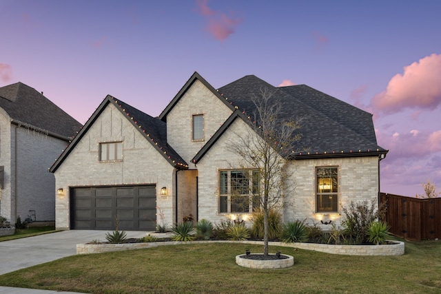 french country home with a yard and a garage